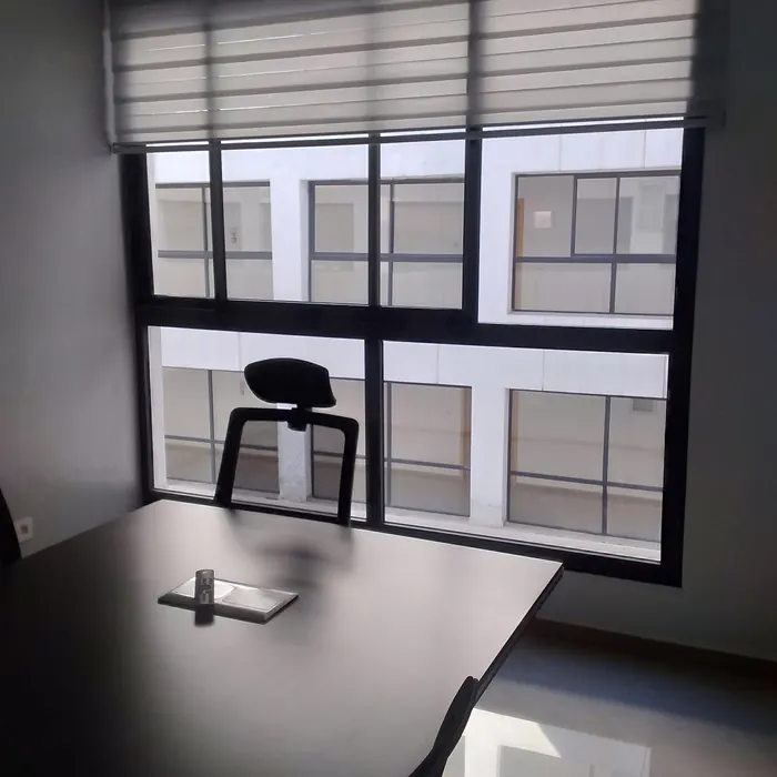 Zebra blinds drawn across a wide office window