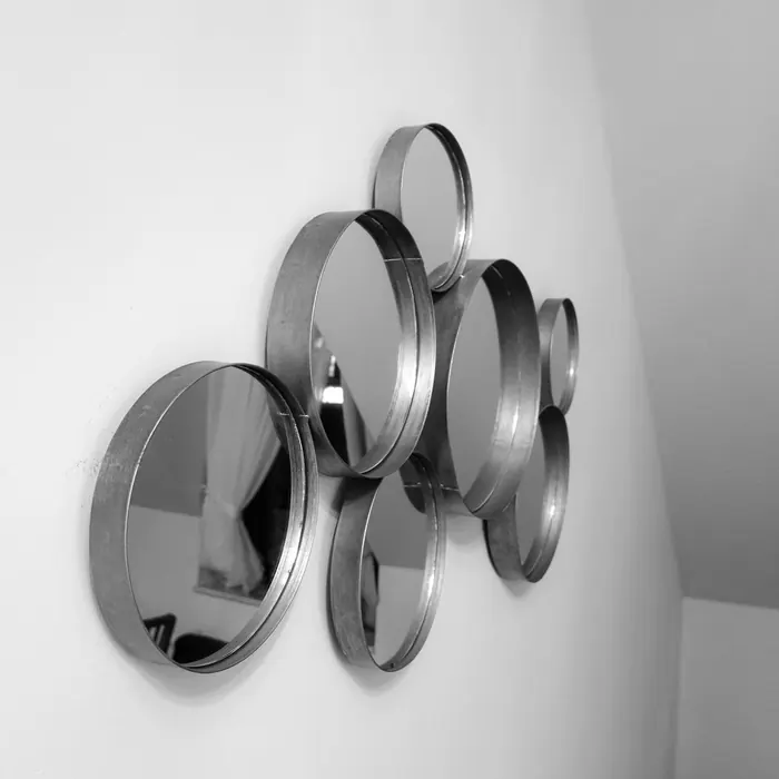 Cluster of round mirrors mounted on a plain wall