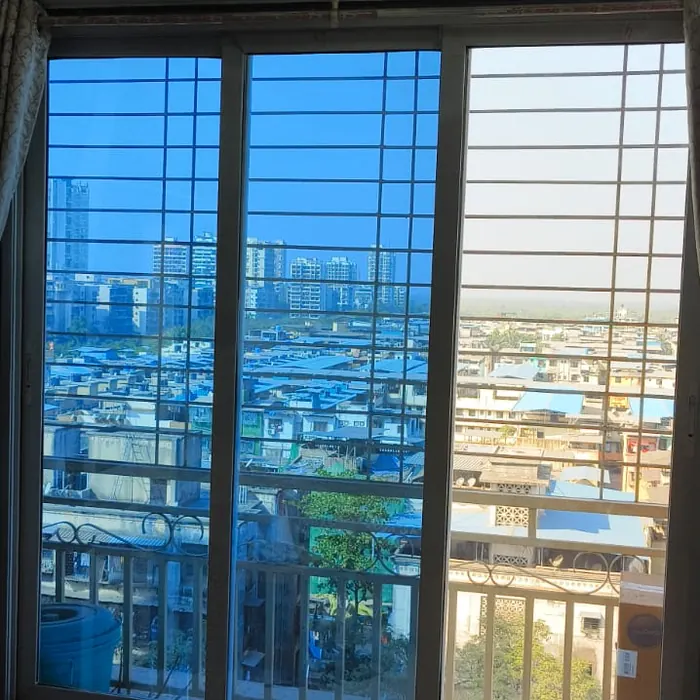Bedroom window filmed against a bright harbour view