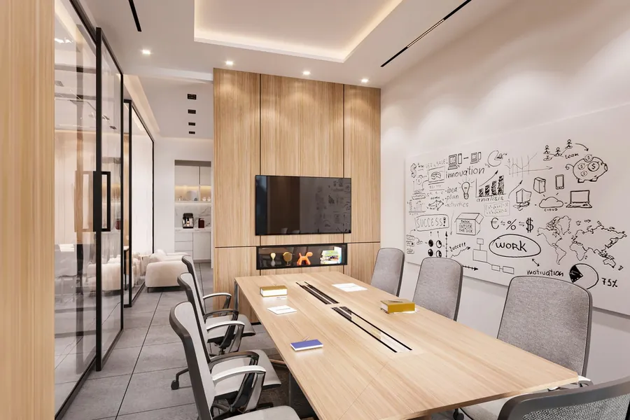Meeting room wall written over in dry-erase marker beside a glass partition